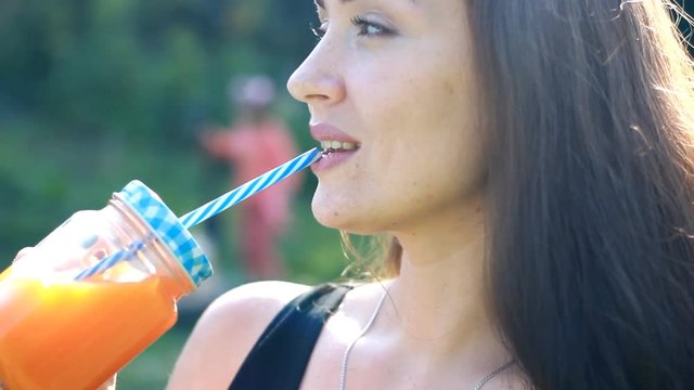 Woman drinks smoothies or orange fresh.