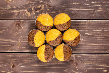 Group of seven whole fresh baked marble muffin flatlay on brown wood