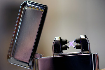 Plasma arc lighter. Windproof, flameless and rechargeable electric lighter. Close up image with...