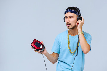 fashionable bright man in headphones in retro style manifestation of emotions of joy, gestures with hands space for text