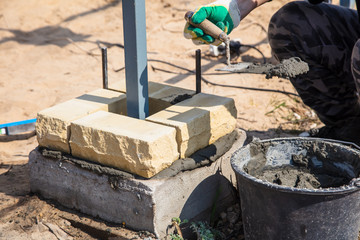 The worker lays bricks on the construction site