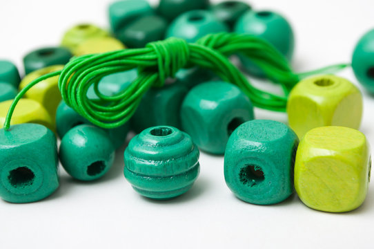 closeup of green wooden beads on white background