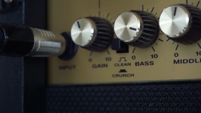 Closeup of turning the bass up on a guitar amp