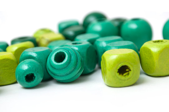 closeup of green wooden beads on white background