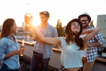 Group of happy friends having party on rooftop