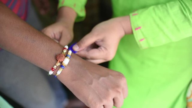 Indian girl ties Rakhi on her brother's hand in the occasion of Raksha bandhan
