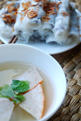 Banh cuon-vietnamese steamed rice rolls with minced meat inside  and pieces of vietnamese ham accompanied by bowl of fish sauce.