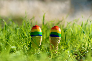 Lgbt couple family. Eggs with lgbt flag color in ice cream waffle cone on nature spring outdoor background. Creative idea for illustration gay parade, lgbt party, homosexual marriage, valentines day.