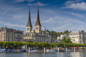 Twin spires church of St. Leodegar and lakeside National Quay Lake in Lucerne, Switzerland.