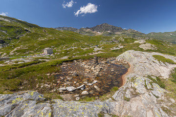 Landscape to the alpine mountains with rock cairns snd staked stones, San Bernardino mountain pass, Switzerland.