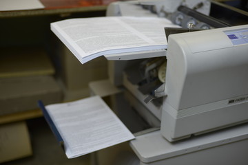 Фолдер складывает листы бумаги пополам