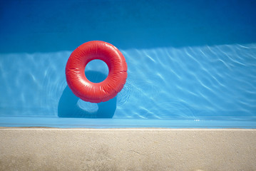 Retro style swimming pool with a vivid red inflatable swim ring