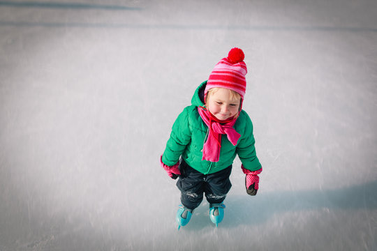 little girl learn to skate in winter nature