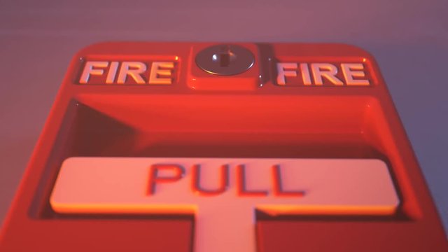 Fire alarm switch on a wall in a conflagration smoke. Button lit by fire flames.