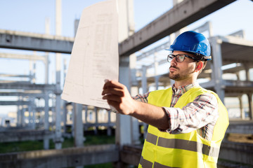 Picture of construction site engineer looking at plan