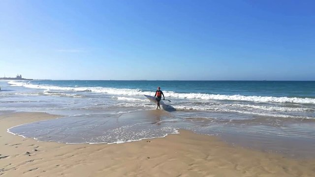 Surfski paddler coming ashore from the ocean.