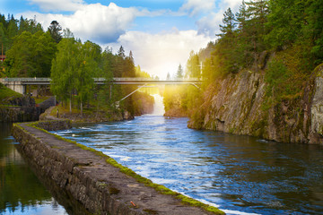 Bridge above the river and waterfall. View of the Telemark Canal with old locks - tourist attraction in Skien, Norway - obrazy, fototapety, plakaty