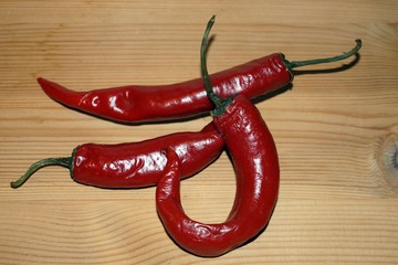 sharp red peppers on wooden table