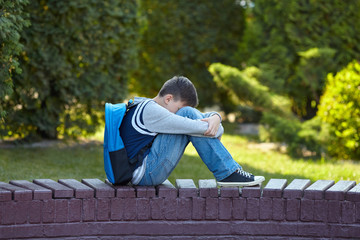 Schoolboy crying in the yard of the school