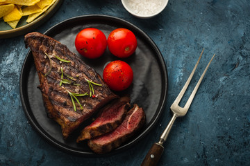 Delicious beef steak with salad, aromatic herbs, chery tomatoes