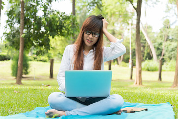 Girl freelance doing her job in the park. a difficult decision