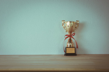 champion golden trophy placed on wooden table