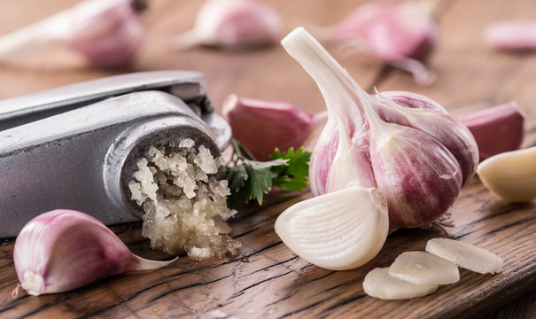 Fototapeta Garlic bulb and garlic cloves  on the wooden table.