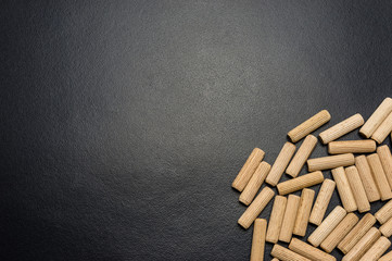 A lot of wooden pegs lying flat on a black background.