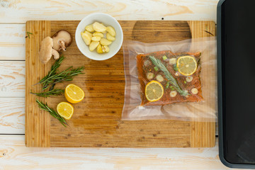 Packaged fish fillet sitting next to vacuum packer