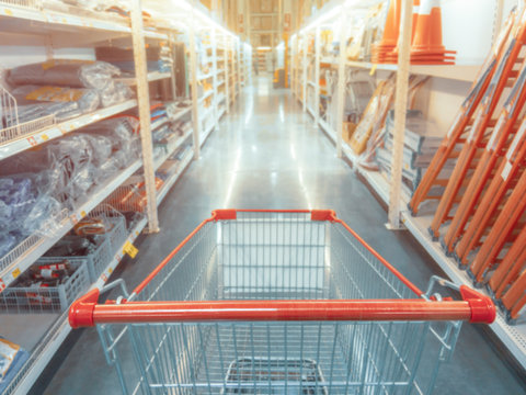 Abstract blurred photo of hardware store with empty shopping cart.