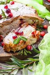 Delicious cranberry pie with fresh cranberries and herbs for Christmas on wooden plate