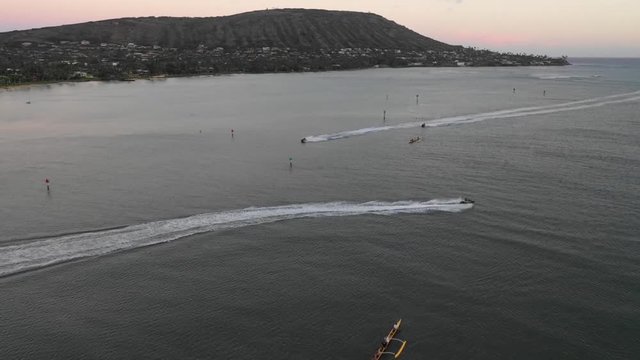 Sunset on the coast of Honolulu in Hawaii. Boats, Jets Skis, and Cars