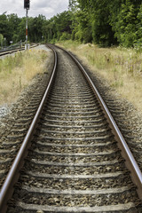 Fototapeta na wymiar Railway track curved into the forest