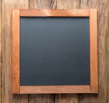 Blackboard on wooden background.