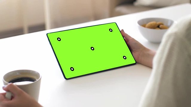 business and technology concept - woman with chroma key green screen on tablet pc computer and coffee at table