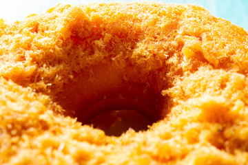 side view studio shoot of donut with shredded pork on top close up