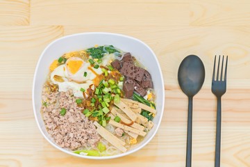 Vietnamese Rice Noodle Soup with pork spare ribs , Pork blood cubes and egg boiled on wood background.