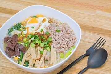 Vietnamese Rice Noodle Soup with pork spare ribs , Pork blood cubes and egg boiled on wood background.