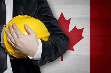 Engineer with yellow plastic helmet on a Canadian flag background