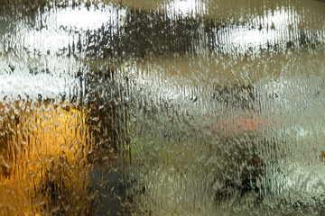 Autumn mood texture for design. Drops of a rain flow down on a smooth surface. Indistinct focus