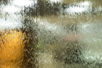 Autumn mood texture for design. Drops of a rain flow down on a smooth surface. Indistinct focus