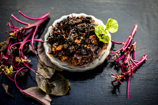 Close up of popular dish of amaranth leaves or chauli or chowli or chaulai or thotakura or harive soppu in a glass plate with raw amaranth leaves and spices.