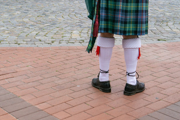 The legs of a man in a tartan skirt
