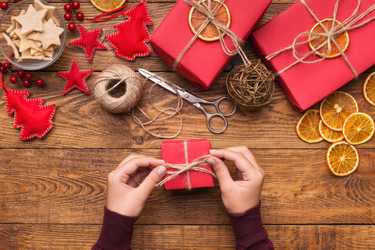 Woman decorating handmade craft Christmas gift boxes