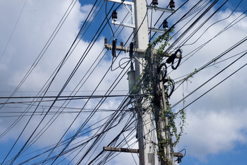 Technology of many electric cable on the pole under blue sky in Thailand.