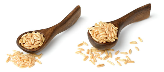 uncooked oats in the wooden spoon, isolated on white