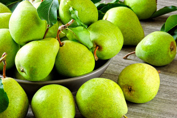 Fresh green pears in a bowl. The harvest of pears.