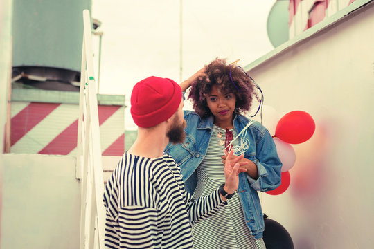 Looking Bad. Tired Young Girl Touching Her Curly Hair And Looking At Her Sleepy Boyfriend After Night Party