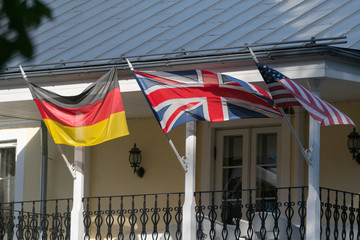 German, British and American flags waving in the wind on the old house