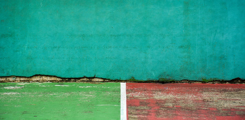 green and red tennis court and wall for practice